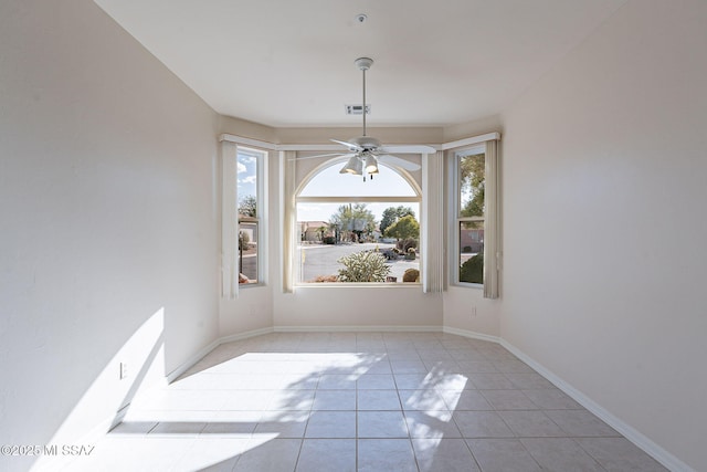 unfurnished dining area with light tile patterned floors, a ceiling fan, visible vents, and baseboards