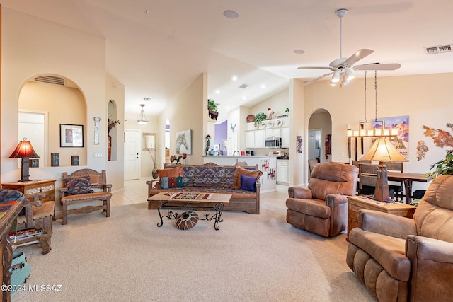 living room featuring light colored carpet, arched walkways, visible vents, and high vaulted ceiling