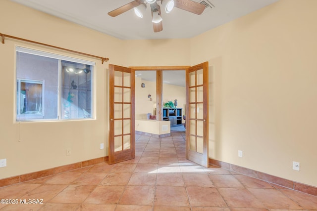 empty room with ceiling fan and french doors