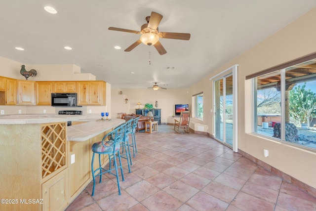 kitchen with a breakfast bar area, tile countertops, light tile patterned floors, light brown cabinets, and kitchen peninsula