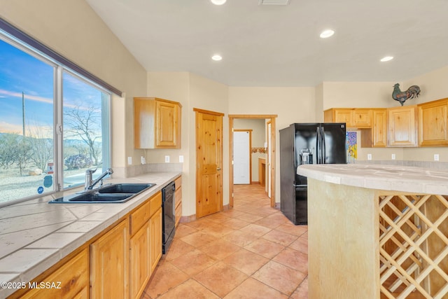 kitchen with light brown cabinetry, sink, tile countertops, and black appliances