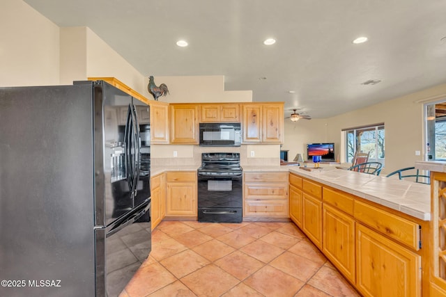 kitchen with light tile patterned flooring, tile counters, ceiling fan, and black appliances