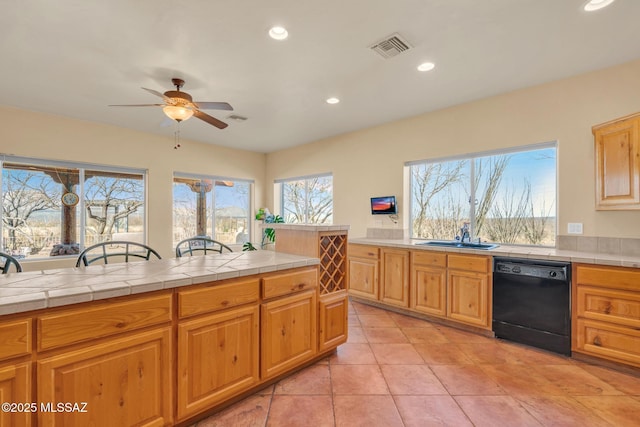 kitchen featuring dishwasher, sink, tile counters, and a wealth of natural light