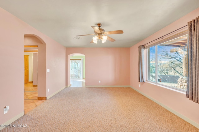 unfurnished room with light colored carpet and ceiling fan