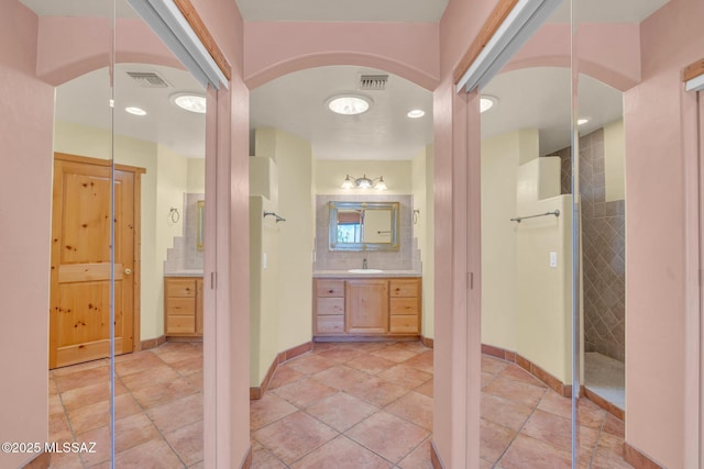 bathroom featuring tile patterned floors, vanity, and decorative backsplash