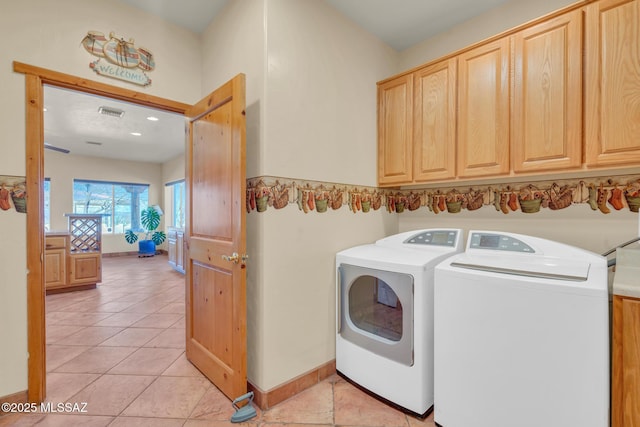 laundry room featuring cabinets, separate washer and dryer, and light tile patterned floors