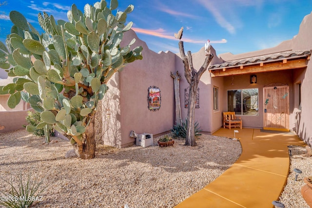 property exterior at dusk with a patio