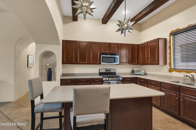 kitchen with beamed ceiling, stainless steel appliances, a kitchen island, and sink