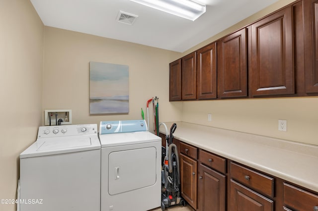 laundry room with washer and dryer and cabinets