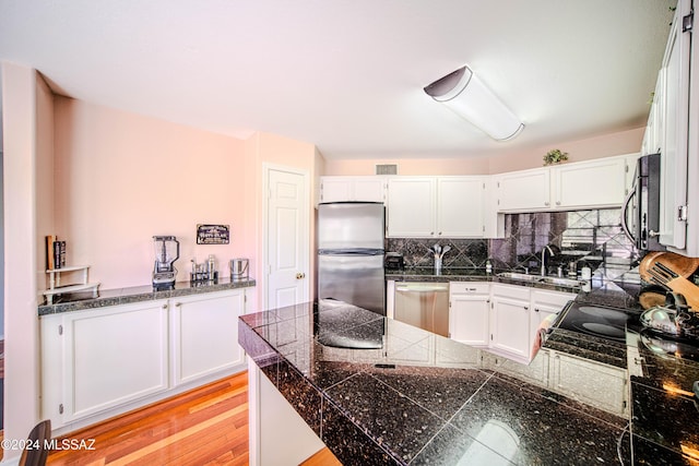 kitchen featuring white cabinets, appliances with stainless steel finishes, and light hardwood / wood-style flooring