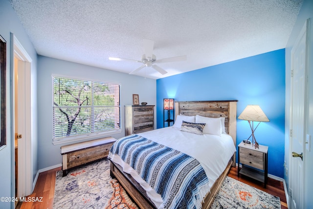 bedroom featuring hardwood / wood-style floors, a textured ceiling, and ceiling fan