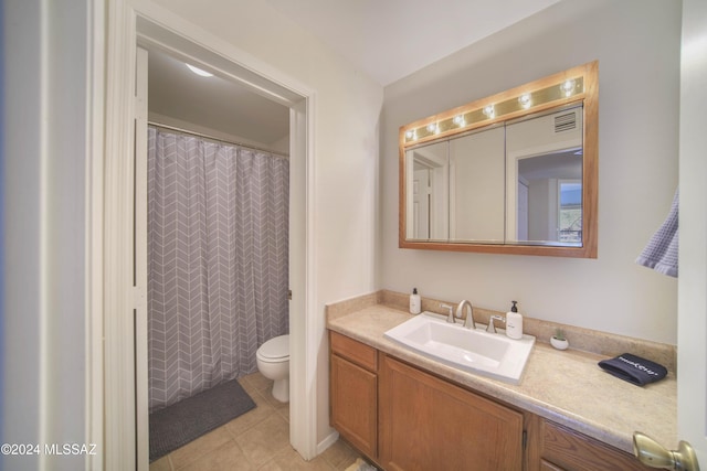 bathroom with tile patterned floors, vanity, toilet, and walk in shower