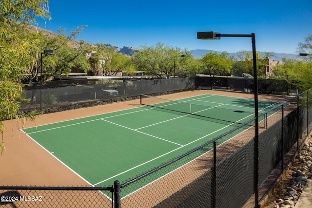 view of sport court with basketball hoop and a mountain view