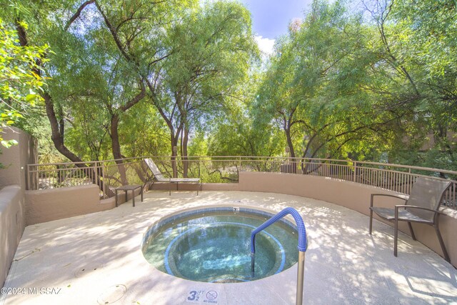 view of swimming pool featuring a community hot tub and a patio