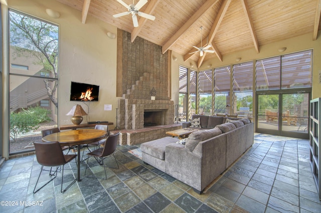 living room featuring beam ceiling, a fireplace, high vaulted ceiling, and wood ceiling