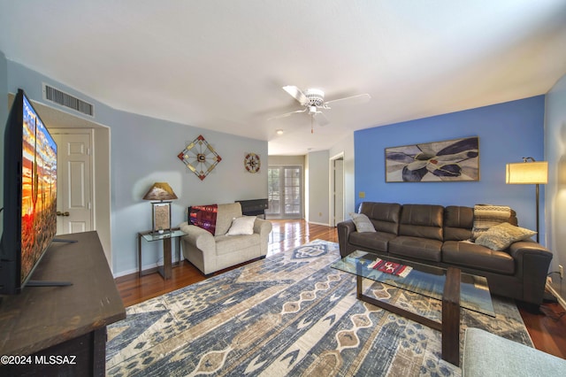 living room with ceiling fan and dark hardwood / wood-style flooring