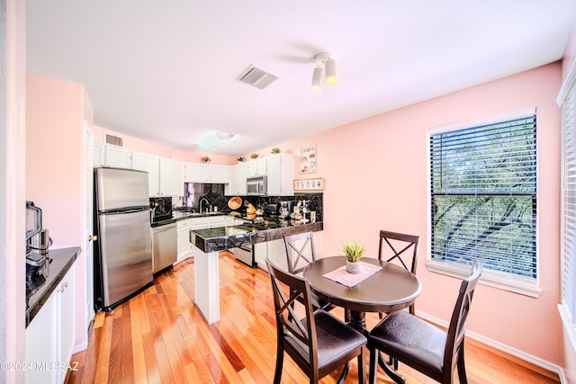 kitchen featuring white cabinetry, sink, light wood-type flooring, and appliances with stainless steel finishes