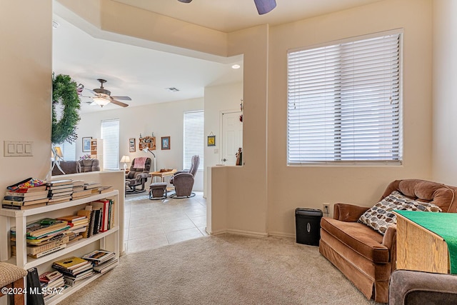 living area featuring ceiling fan and light carpet