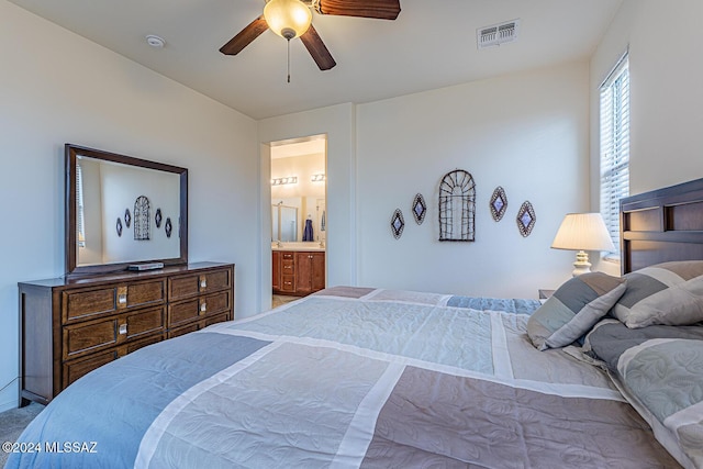 carpeted bedroom featuring ceiling fan and ensuite bathroom