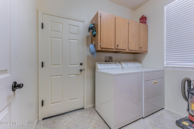 clothes washing area featuring cabinets, light tile patterned floors, and washing machine and dryer