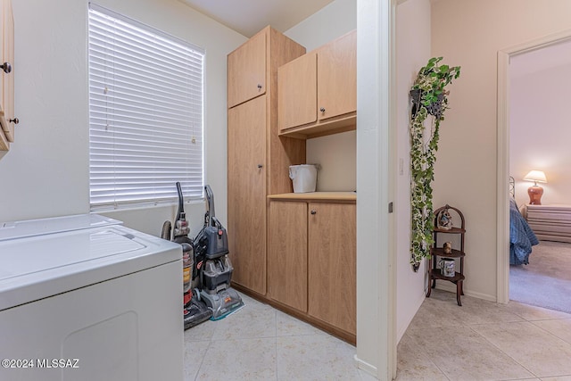 laundry room featuring cabinets and light tile patterned flooring