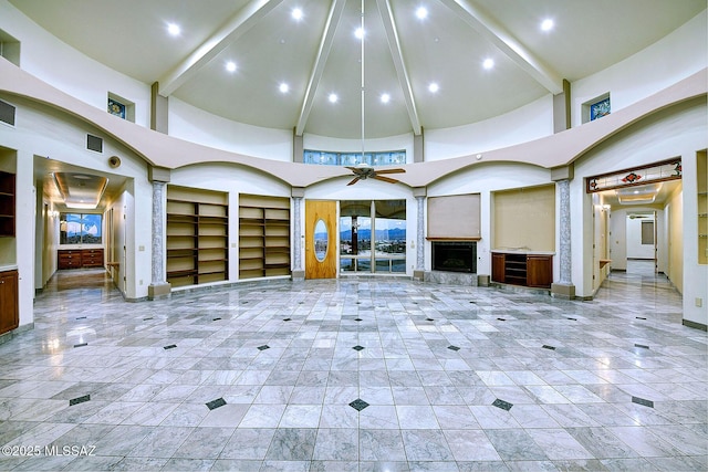 unfurnished living room featuring ceiling fan, a towering ceiling, and beamed ceiling