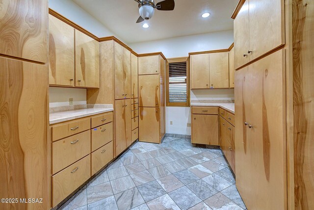 kitchen featuring ceiling fan and light brown cabinets