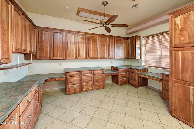 tiled office space featuring ceiling fan and built in desk