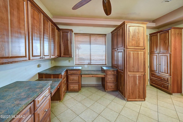 kitchen featuring built in desk, ceiling fan, and light tile patterned flooring