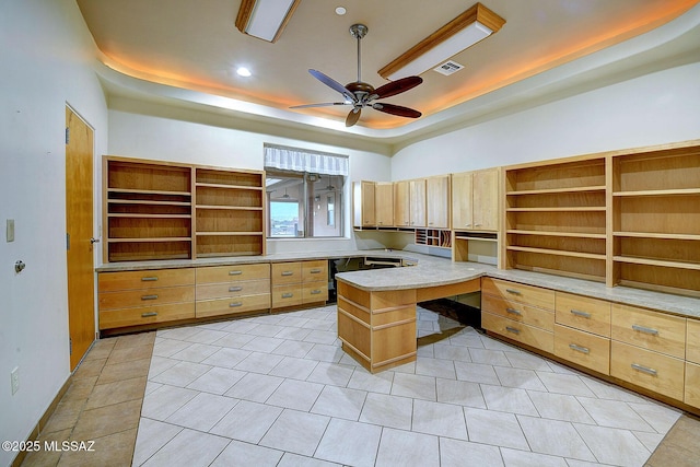 home office featuring ceiling fan, light tile patterned floors, and a raised ceiling