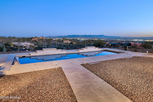 view of swimming pool featuring a patio area and a mountain view