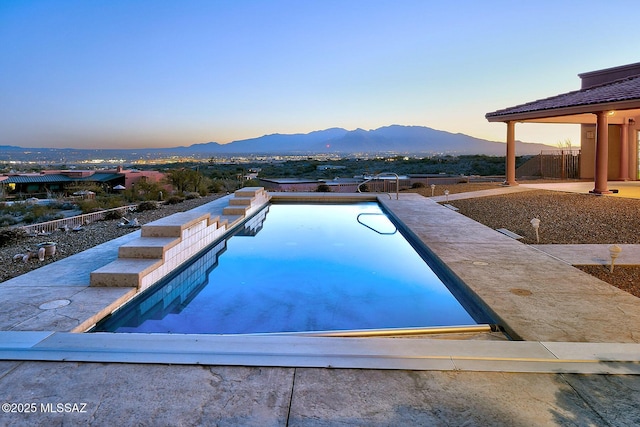 pool at dusk featuring a mountain view