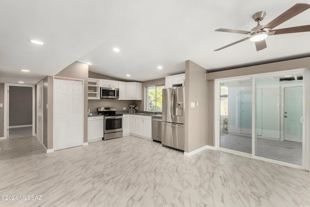 kitchen featuring ceiling fan, stainless steel appliances, vaulted ceiling, and white cabinets