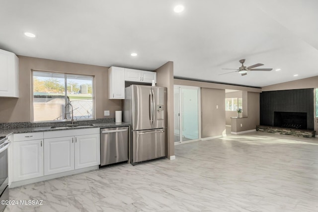 kitchen featuring a healthy amount of sunlight, appliances with stainless steel finishes, sink, and white cabinets