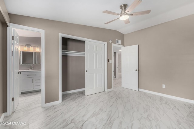 unfurnished bedroom featuring connected bathroom, vaulted ceiling, a closet, and ceiling fan