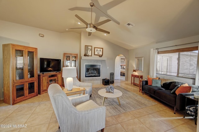 living area with light tile patterned floors, visible vents, arched walkways, and a tiled fireplace