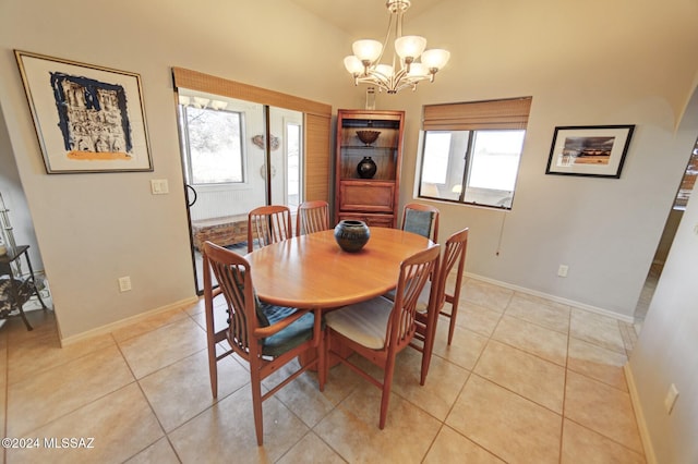 dining area with light tile patterned flooring, a chandelier, and baseboards