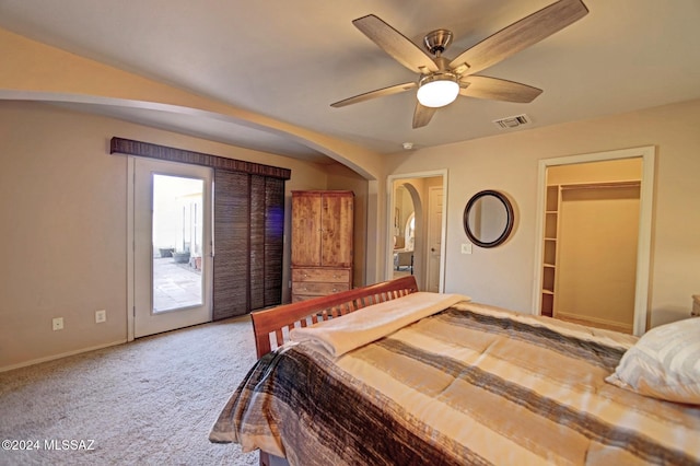 bedroom featuring carpet, visible vents, arched walkways, ceiling fan, and access to outside