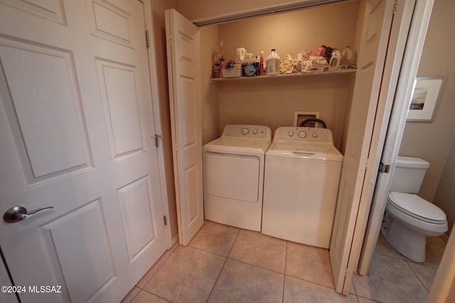 laundry area featuring light tile patterned floors, laundry area, and washing machine and clothes dryer