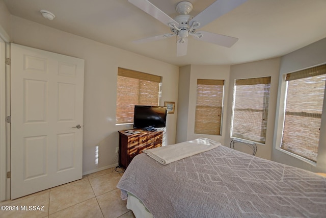 bedroom with light tile patterned floors, baseboards, and ceiling fan