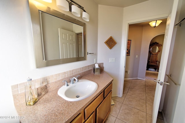 bathroom featuring tile patterned flooring, vanity, and tasteful backsplash