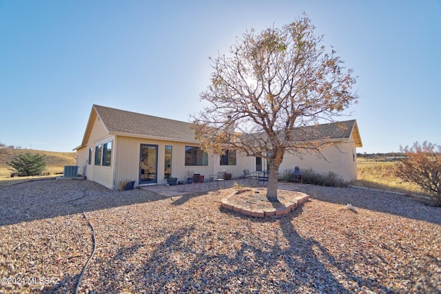 rear view of house with central air condition unit and a patio