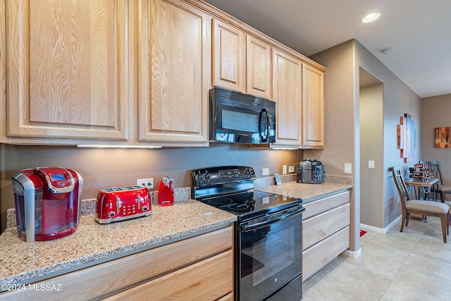 kitchen with light stone countertops, light brown cabinets, light tile patterned floors, and black appliances