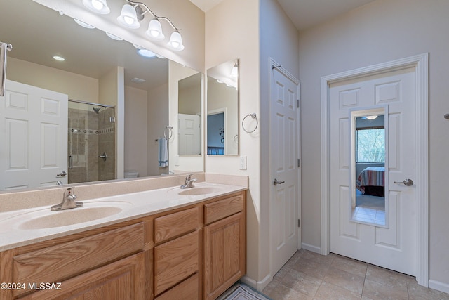 bathroom featuring tile patterned floors, vanity, toilet, and a shower with door