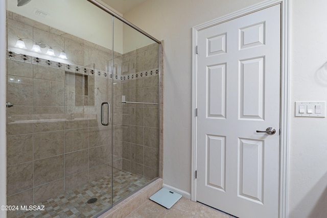 bathroom with tile patterned flooring and a shower with door