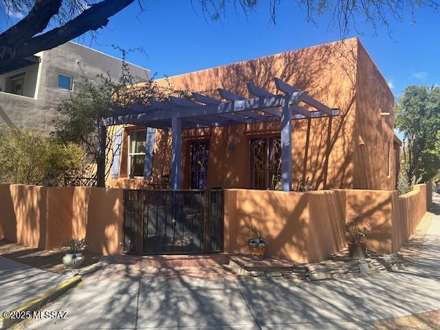 view of front of property featuring a fenced front yard, a gate, and a pergola