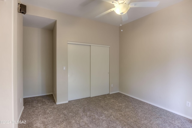 unfurnished bedroom with carpet, a closet, ceiling fan, and baseboards