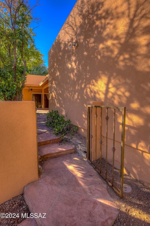 exterior space featuring a gate, a patio area, and stucco siding