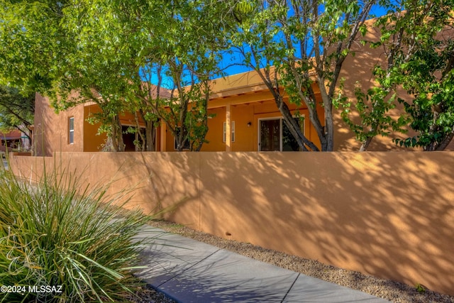 pueblo-style house featuring a fenced front yard and stucco siding