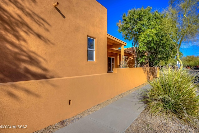 view of property exterior featuring fence and stucco siding